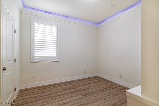 unfurnished room featuring light wood-style floors, ornamental molding, and baseboards