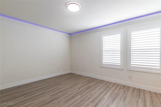 unfurnished room featuring light wood-style floors, ornamental molding, and baseboards