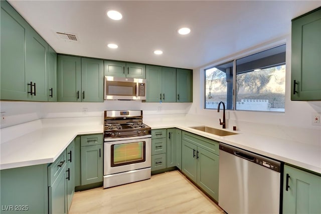 kitchen with stainless steel appliances and green cabinetry