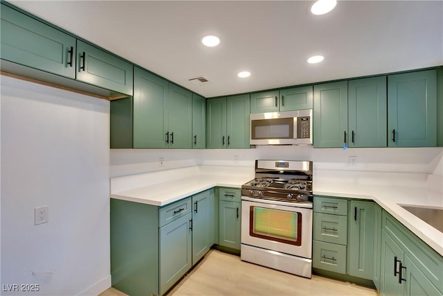 kitchen with green cabinets, stainless steel appliances, and visible vents