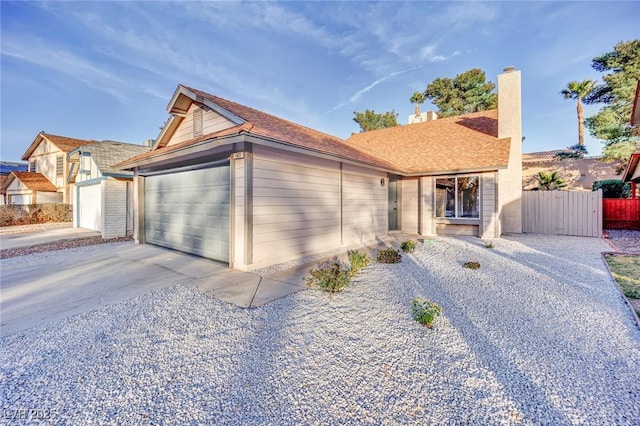 ranch-style home featuring a garage, driveway, and fence