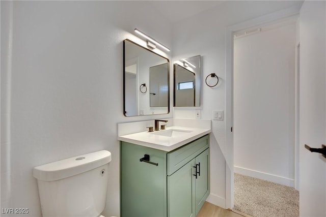 bathroom featuring baseboards, vanity, and toilet