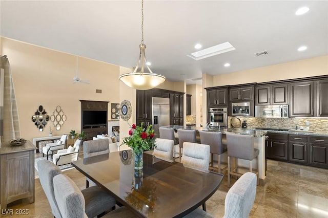 dining space with a skylight, visible vents, and recessed lighting