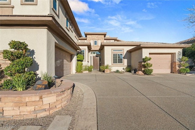 view of front facade featuring a garage, concrete driveway, and stucco siding