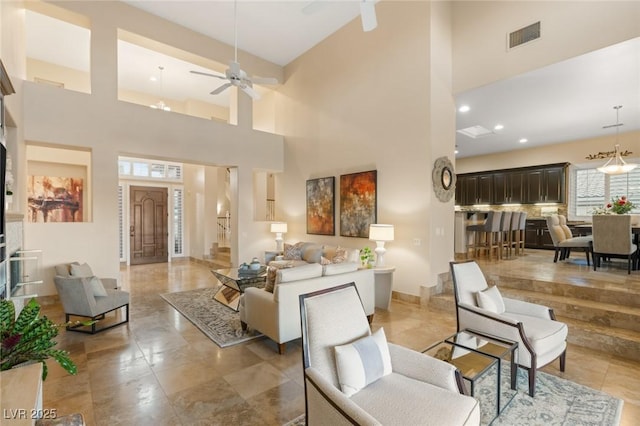 living area with recessed lighting, a high ceiling, visible vents, a ceiling fan, and stairway