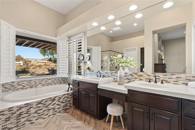 full bathroom with a stall shower, tasteful backsplash, a garden tub, vanity, and recessed lighting