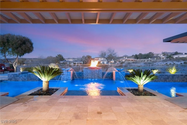 pool at dusk featuring a patio area and a fenced backyard