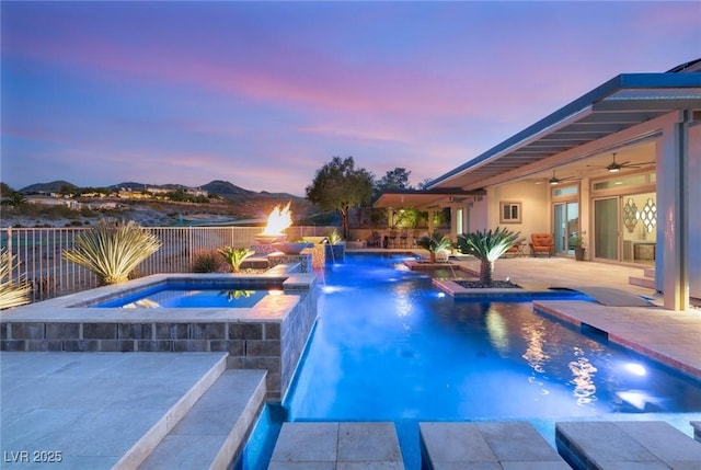 view of pool featuring a pool with connected hot tub, a patio area, ceiling fan, and fence