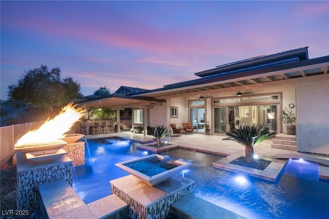 view of pool featuring fence, a pool with connected hot tub, a ceiling fan, outdoor dry bar, and a patio area