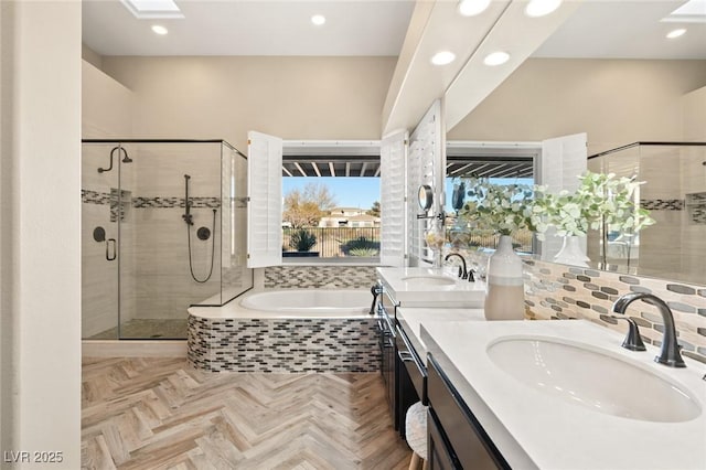 bathroom featuring a garden tub, double vanity, a sink, and a shower stall