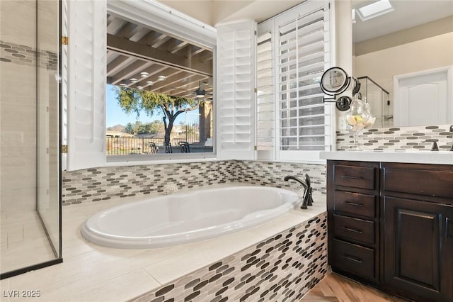 full bathroom with a garden tub, a shower stall, decorative backsplash, and vanity