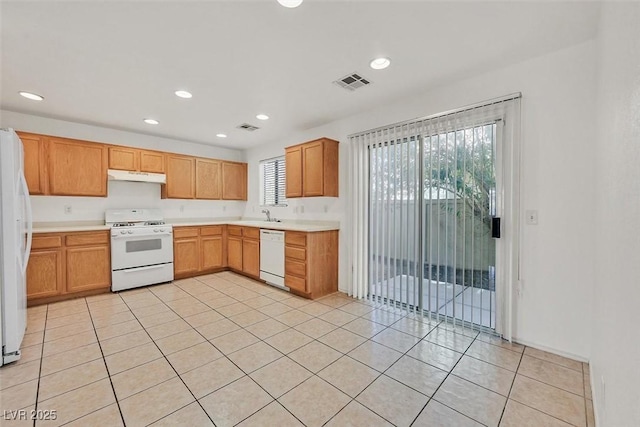 kitchen featuring under cabinet range hood, visible vents, white appliances, and light countertops