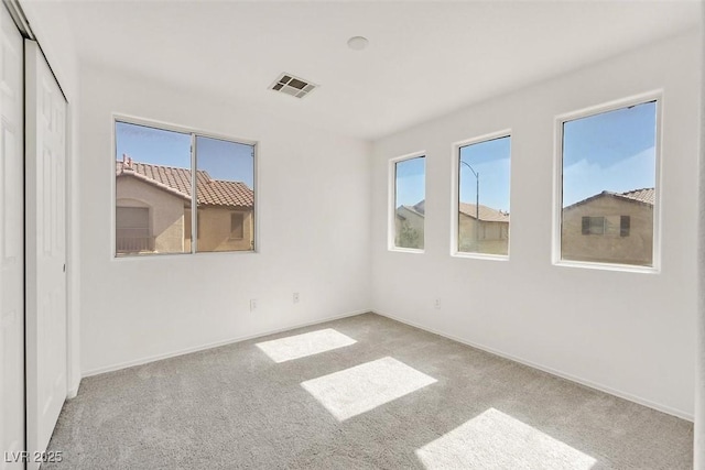 empty room with visible vents, baseboards, and carpet floors