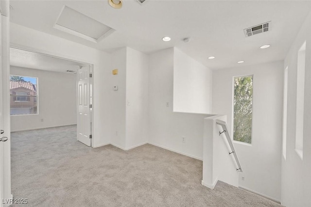 carpeted spare room with visible vents, recessed lighting, attic access, and baseboards