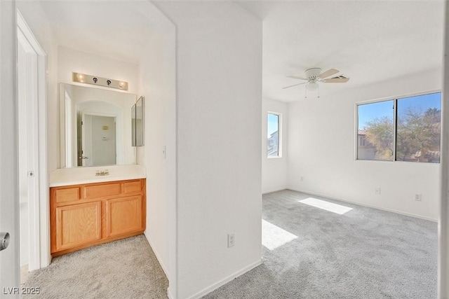 interior space featuring a wealth of natural light, ceiling fan, and vanity