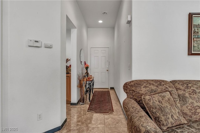 corridor with light tile patterned floors, baseboards, and visible vents