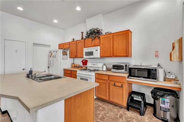 kitchen featuring white appliances, a toaster, brown cabinets, light countertops, and a sink