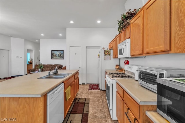 kitchen with white appliances, an island with sink, light countertops, a sink, and recessed lighting