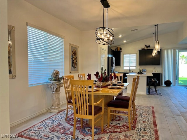 dining space featuring a chandelier, lofted ceiling, and visible vents