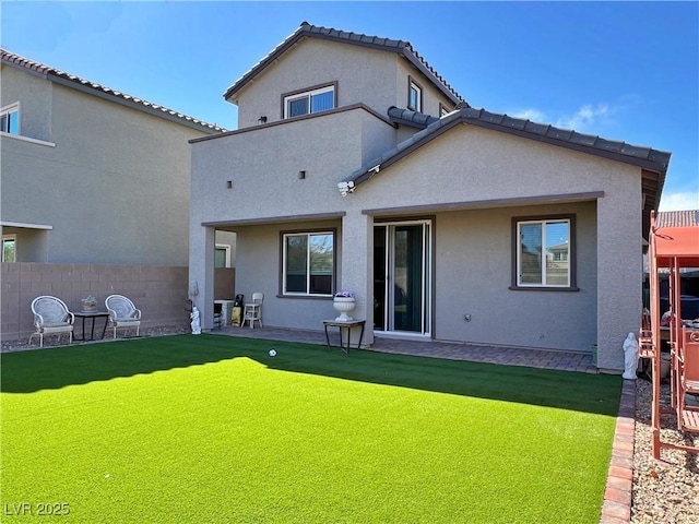 back of house with a patio, a yard, fence, and stucco siding