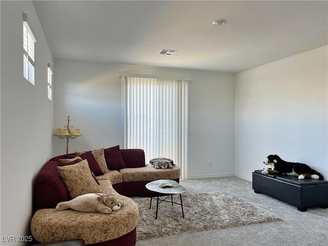 carpeted living room featuring visible vents and baseboards