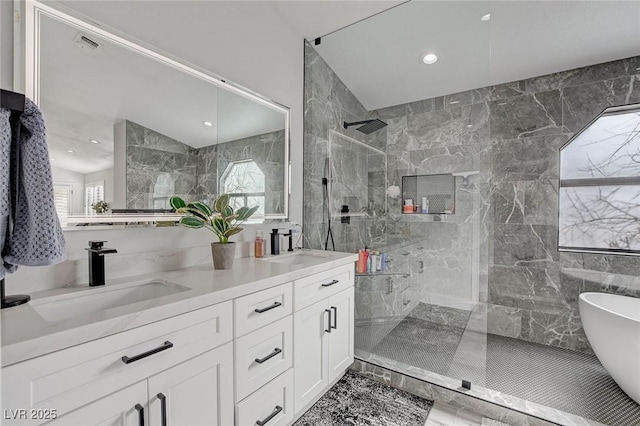 full bath with a wealth of natural light, a sink, tile walls, and a marble finish shower