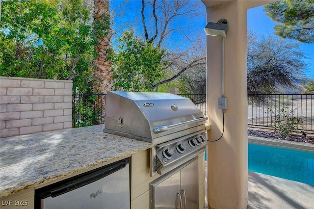 view of patio featuring area for grilling, fence, and a grill