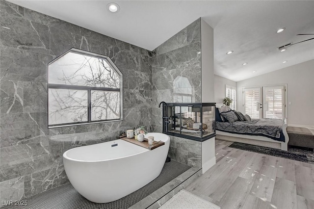 ensuite bathroom featuring recessed lighting, ensuite bathroom, vaulted ceiling, wood finished floors, and a freestanding tub