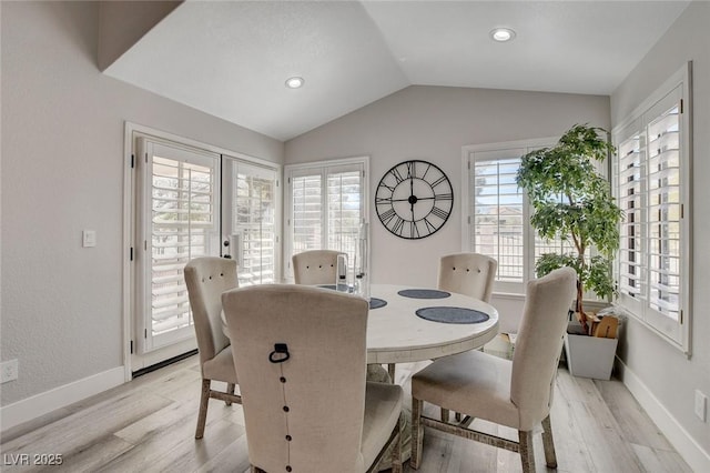 dining space with lofted ceiling, french doors, light wood-type flooring, and baseboards