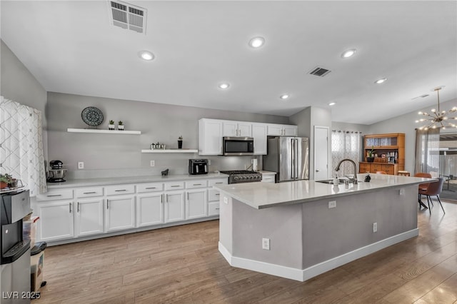 kitchen featuring stainless steel appliances, visible vents, a sink, and open shelves