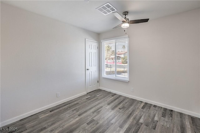 empty room featuring a ceiling fan, baseboards, visible vents, and wood finished floors