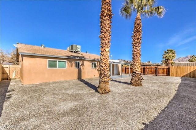 back of property with cooling unit, a patio area, a fenced backyard, and stucco siding