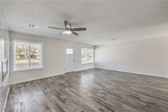 unfurnished living room with ceiling fan, wood finished floors, visible vents, and baseboards