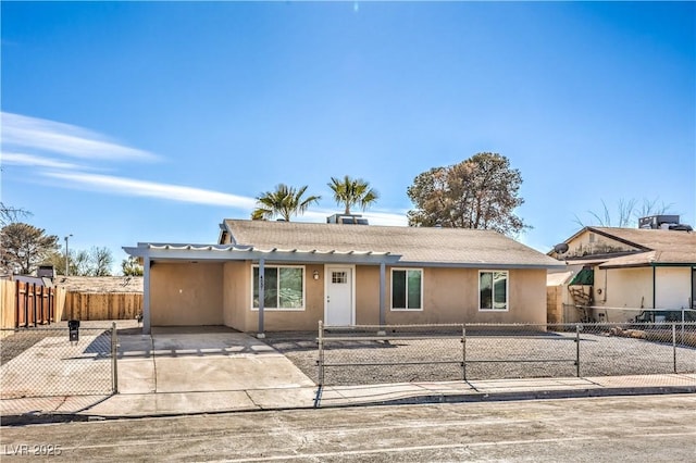 ranch-style house featuring a fenced front yard and stucco siding