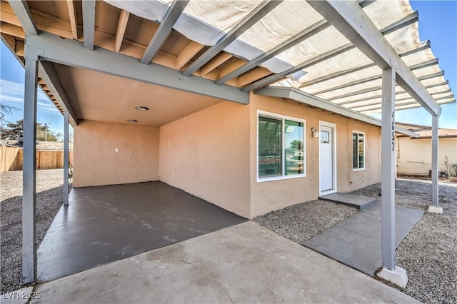 view of patio featuring a carport and fence