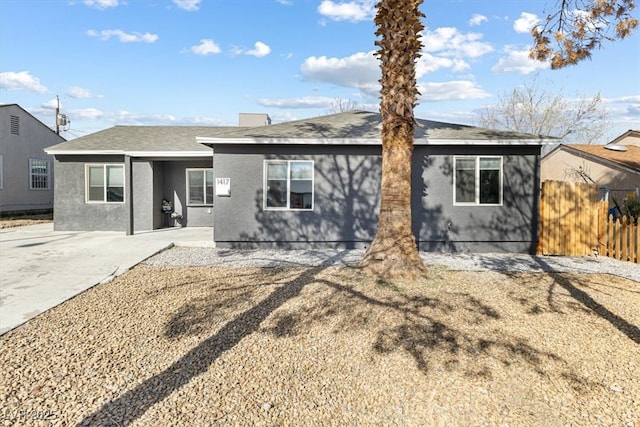 view of front facade featuring stucco siding and fence