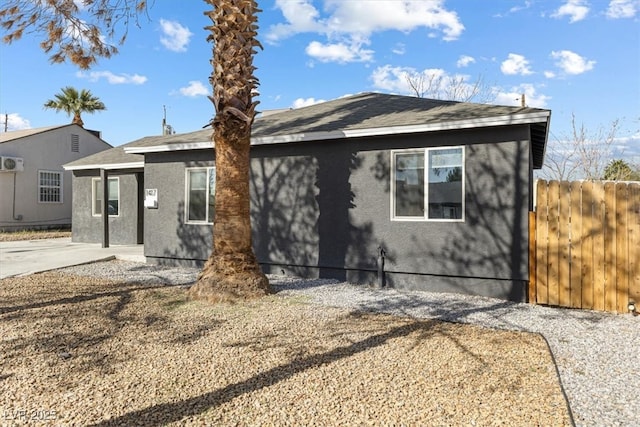 view of front of house with fence and stucco siding