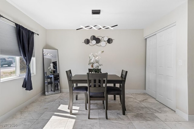 dining area featuring baseboards and marble finish floor