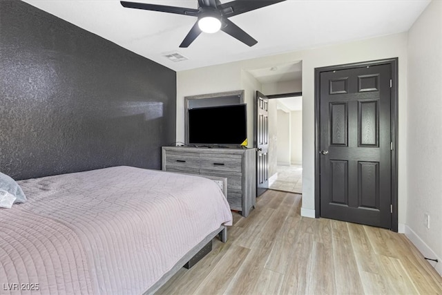 bedroom with ceiling fan, visible vents, baseboards, and light wood-style flooring