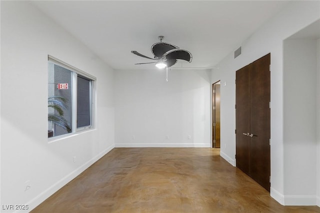 spare room with baseboards, concrete floors, visible vents, and a ceiling fan