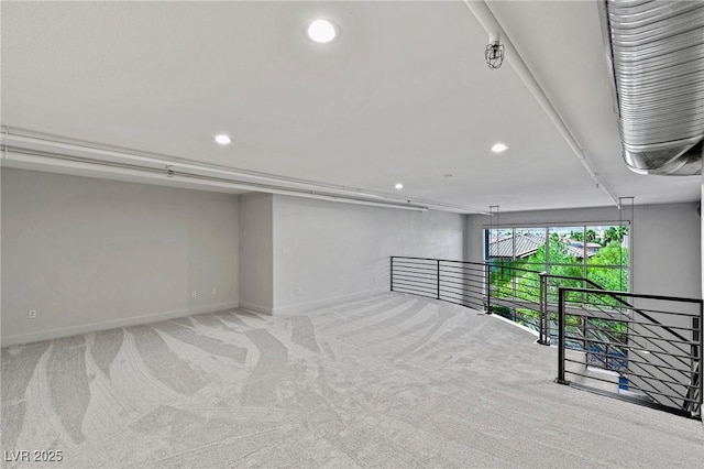 spare room featuring light carpet, baseboards, and recessed lighting