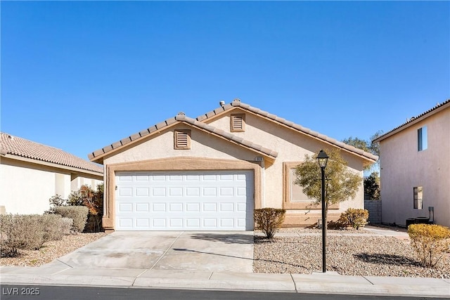 view of front facade featuring a tile roof, driveway, an attached garage, and stucco siding