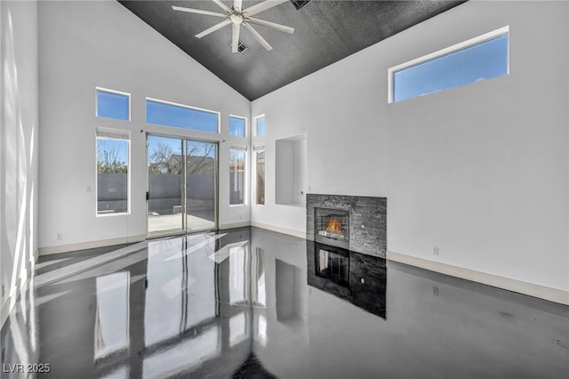 living room with finished concrete flooring, high vaulted ceiling, ceiling fan, and a fireplace