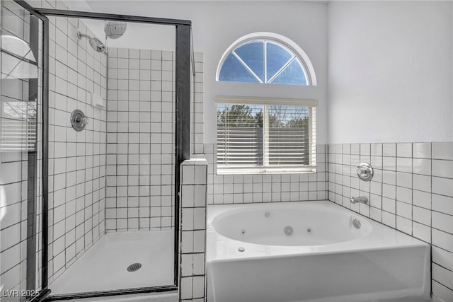 bathroom featuring a whirlpool tub and a stall shower