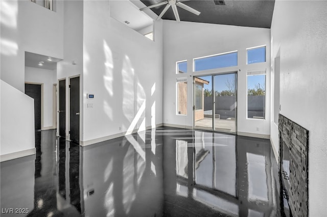 spare room featuring finished concrete flooring, high vaulted ceiling, and visible vents