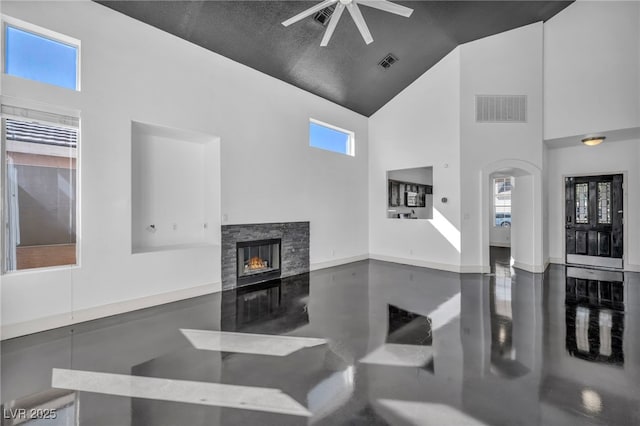 living area with high vaulted ceiling, a stone fireplace, visible vents, and baseboards