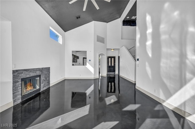 living room with visible vents, stairs, concrete floors, high vaulted ceiling, and a fireplace