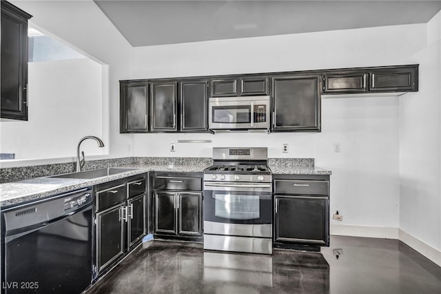 kitchen featuring stainless steel appliances, light countertops, a sink, and dark cabinets