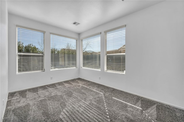 carpeted spare room featuring visible vents