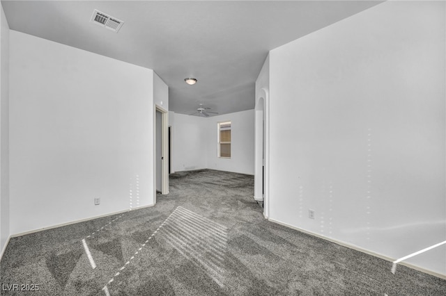 spare room with carpet, visible vents, ceiling fan, and baseboards